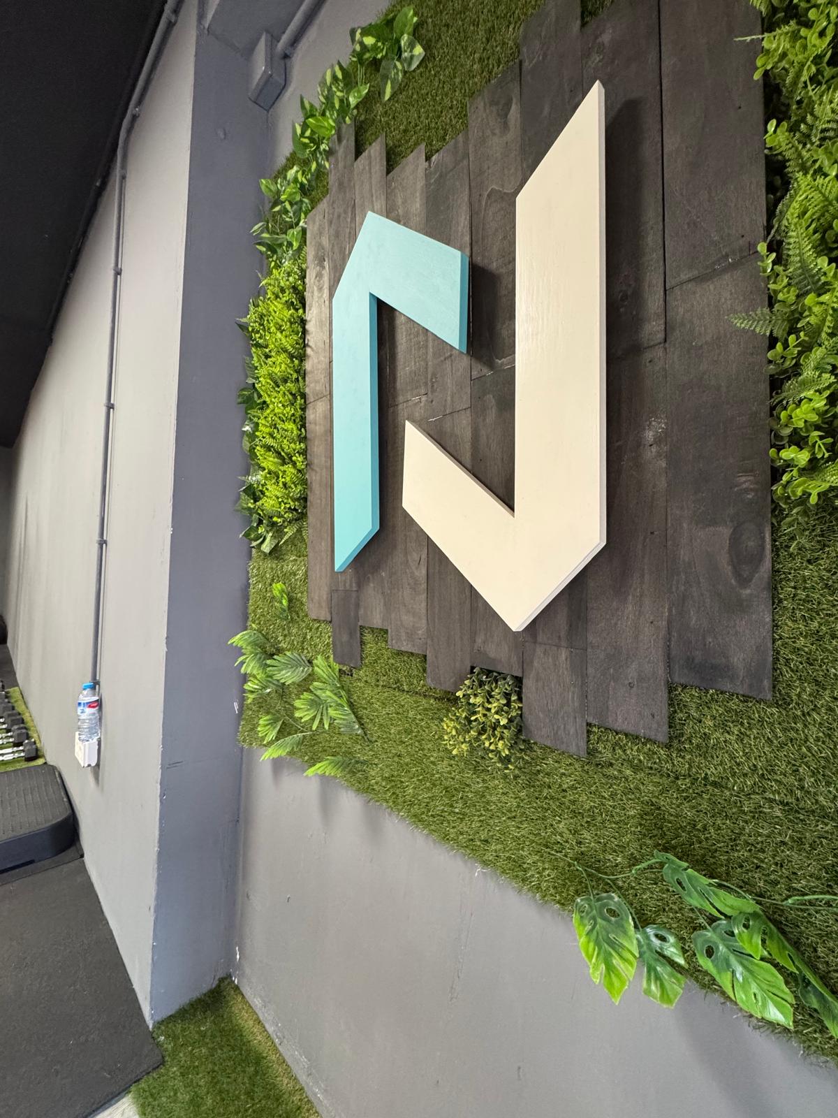 Logo New Fit Life en la pared del centro